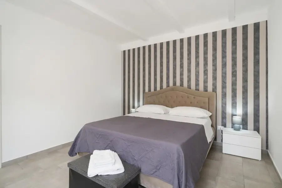 Stanza 2: letto matrimoniale davanti alla parete a righe