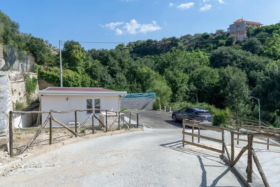 Il viale d'ingresso con un bungalow immerso nella vegetazione